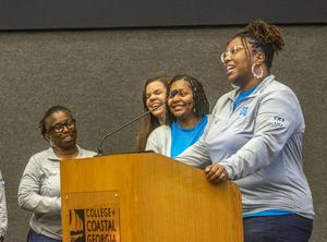 Stephanie Cooper, a Glynn Academy English teacher, talks at the College of Coastal Georgia about her group\'s externship experience at King and Prince Seafood.