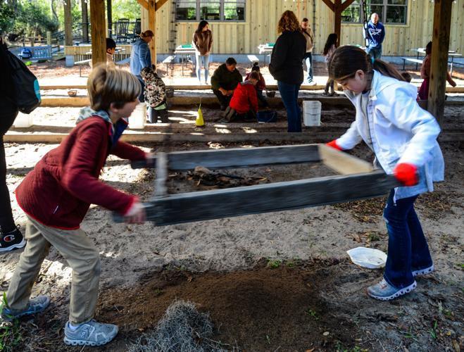 Garrison Spearman, left, and Niah Dixon shake a sifter to separate artifacts from soil at the archaeology study area at Fort Frederica National Monument.