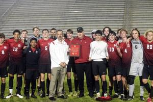 Glynn Academy\'s Bobby Brockman smiles at midfield with his players who earned his 400th win as Terrors coach. The team won 2-0 over Richmond Hill.