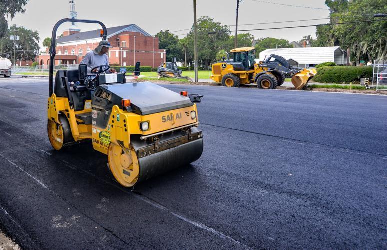 A worker smooths the asphalt in the newly paved parking lot that once was home to Glynn County school board central offices and an annex.