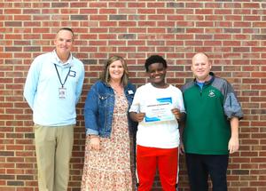 Risley Middle student Christopher Green with school and district administrators.