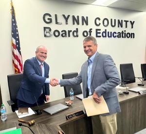 GCSS Board Chairman Dr. Hank Yeargan, left, shakes hands with new superintendent, Mike Blackerby.