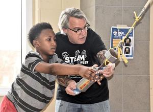Jane Macon Middle School science teacher Abner Zachary shows a student how a pendulum works at GCSS\' recent STEAMFest and Literacy Fair at Brunswick High.