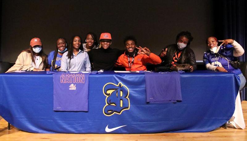 Brunswick High\'s Chuckobe Hill and Ree Simmons pose with family after signing with Savannah State on national signing day.
