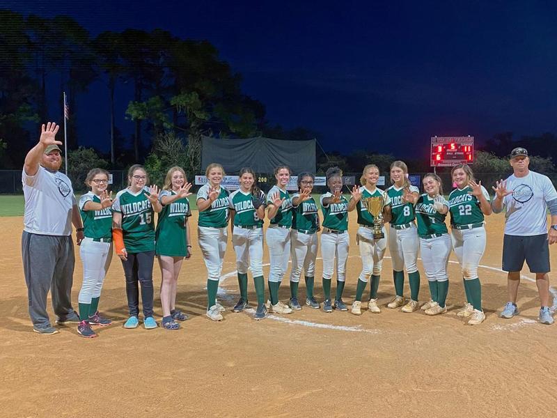 Members of the Risley Middle School softball team pose with the middle school championship trophy after winning the program\'s fifth consecutive title Oct. 27.
