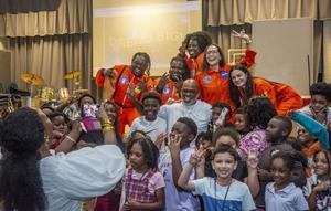 Damon Dash, co-founder of Roc-A-Fella Records, center, wearing white, poses for a photo with Goodyear Elementary students, his wife Raquel Horn, to his left, and the rest of the astronaut performers of their children\'s show, SoOriginal. Adrian, to the left, Micah D\'Vinci, behind Dash to his right, Cadence April in the back and Nicolette at right.