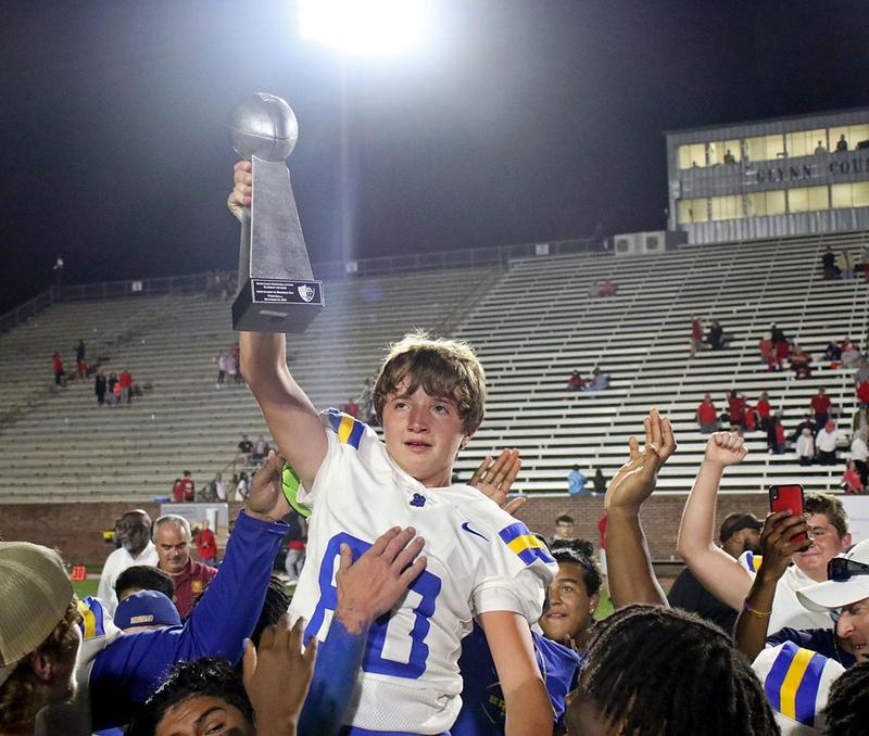 Brunswick High\'s McClain Fineran is lifted by teammates in celebration of his game-winning field goal in overtime of the City Championship game at Glynn County Stadium.
