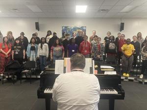 Nathaniel Roper, director of choral and orchestral activities at Glynn Academy, rehearses with the school choir before their Veterans Day concert, which was recently held at the school\'s auditorium.