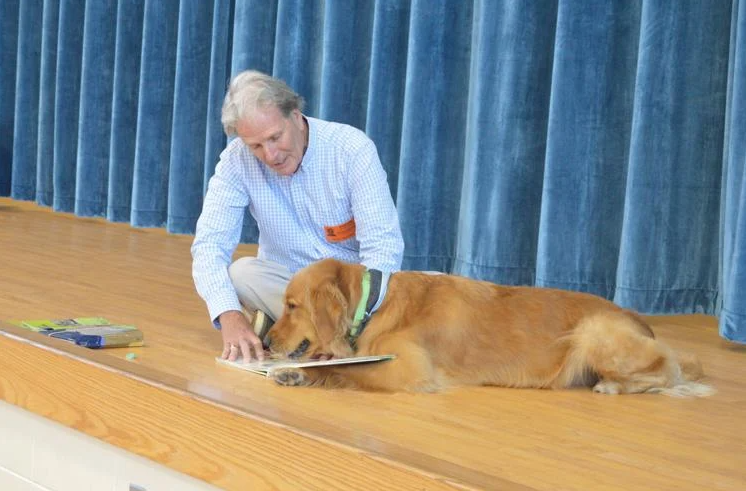 Ronald Binkney and his dog Lucky, a golden retriever and \"silent reader,\' share a book with students at FACES preschool.
