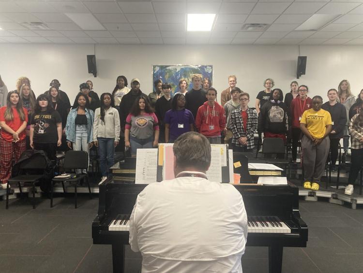 Nathaniel Roper, director of choral and orchestral activities at Glynn Academy, rehearses with the school choir before their Veterans Day concert, which was recently held at the school\'s auditorium.
