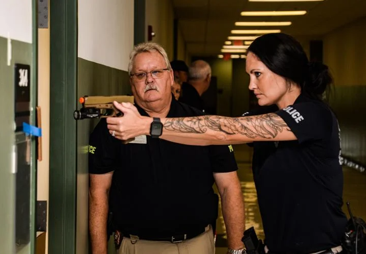 GCSS police officer Jennifer Seawell has her weapon ready as she clears a room during training for school police at the Golden Isles College & Career Academy, while Chief Rod Ellis looks on.