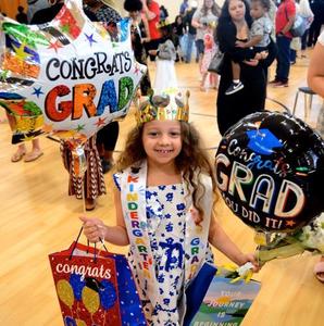 Delilah Brown holds onto balloons and other congratulatory items after she graduated from Altama Elementary kindergarten.
