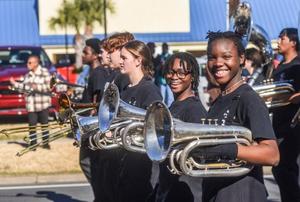 Musicians in the joint Brunswick High and Glynn Academy marching band smile as they pass on Gloucester Street during the annual MLK Day parade in January.