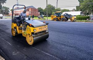 A worker smooths the asphalt in the newly paved parking lot that once was home to Glynn County school board central offices and an annex.