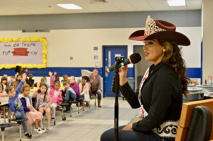 Miss Rodeo USA Kaelanne Quinonez reads to children at Goodyear Elementary School.
