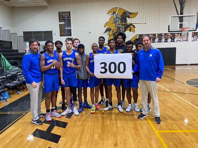 The Brunswick High boys basketball team celebrates head coach Chris Turner\'s 300th win with the program following a victory over Evans on Saturday.