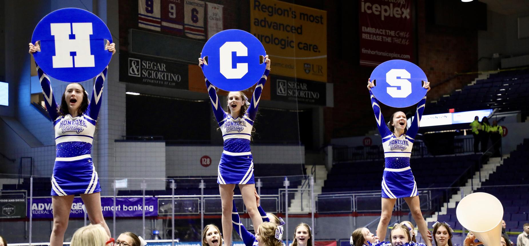 cheerleaders holding signs saying HCS
