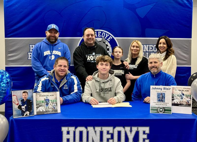 John Blair with family, coaches, superintendent, and athletic director