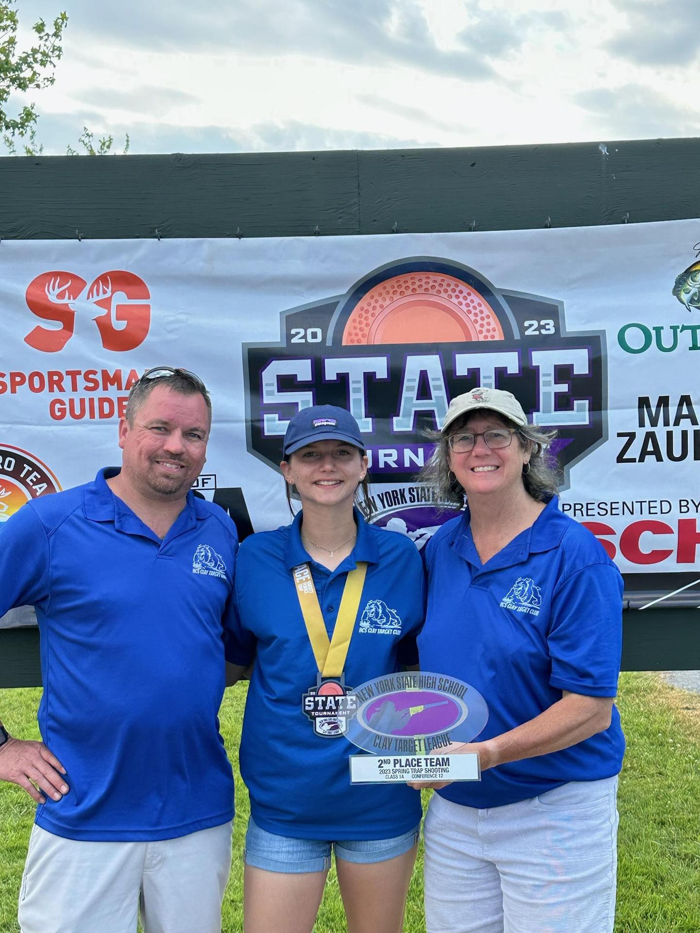 photo of 2 coaches with a champion clay target shooter