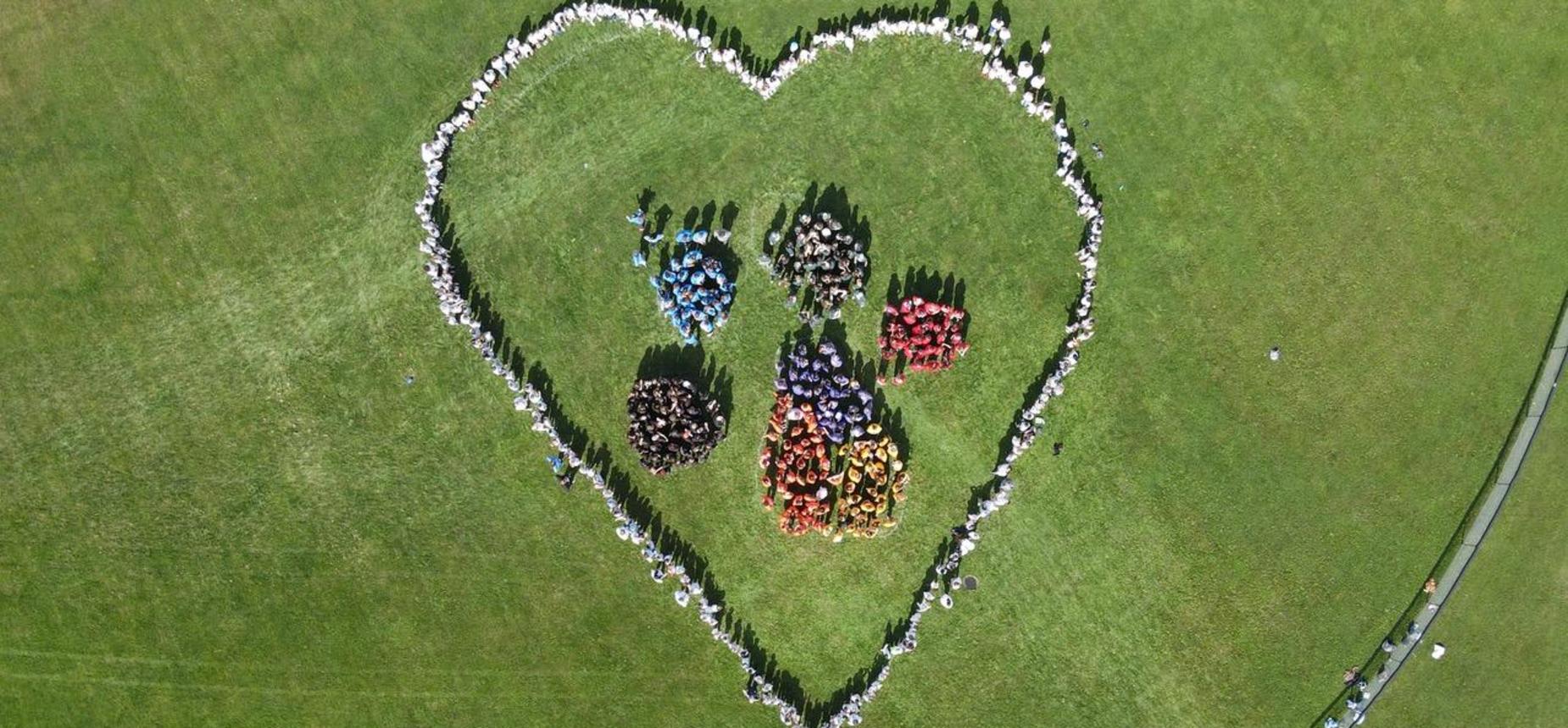 aerial photo of students and staff standing in shape of bulldog paw print with a heart outline
