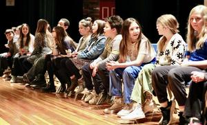 students sitting on stage waiting for Spelling Bee