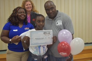 Makayla Burroughs, a fifth grade student at Harry E. James Elementary, stands with her father and representatives from the Better Future Fund, after being named a  winner on April 17.