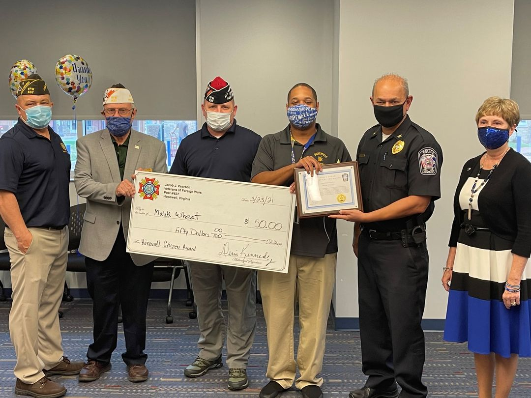 Mr. Malik Wheat, third from the left, holding both his plaque and a big check, stands with three members of VFW Post 637, Chief Kamran Afzal (fourth from the left) and Ms. Jackie Shornak (fifth from the left), Chair of the Chief Advisory Council. Image courtesy of M. Wheat. 
