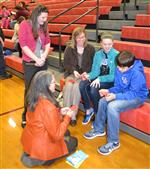 Two teachers talk with students and a parent 