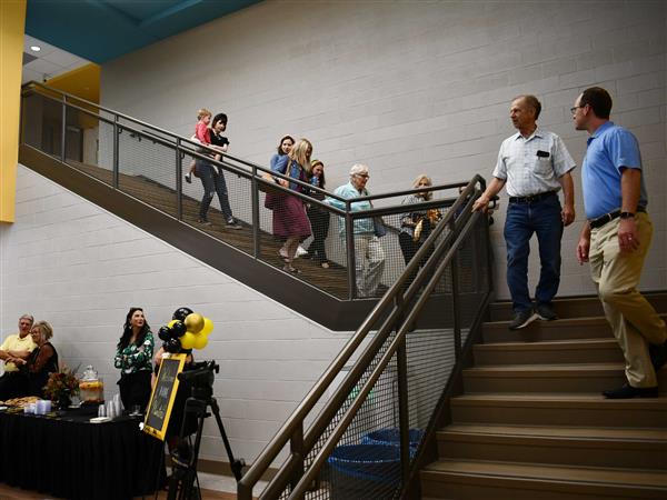 People walking down staircase and pausing on landing