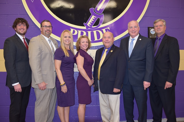 photograph of the members of the Islip Board of Education for the 2022-2023 school year standing in front of the Islip Pride logo at Islip High School