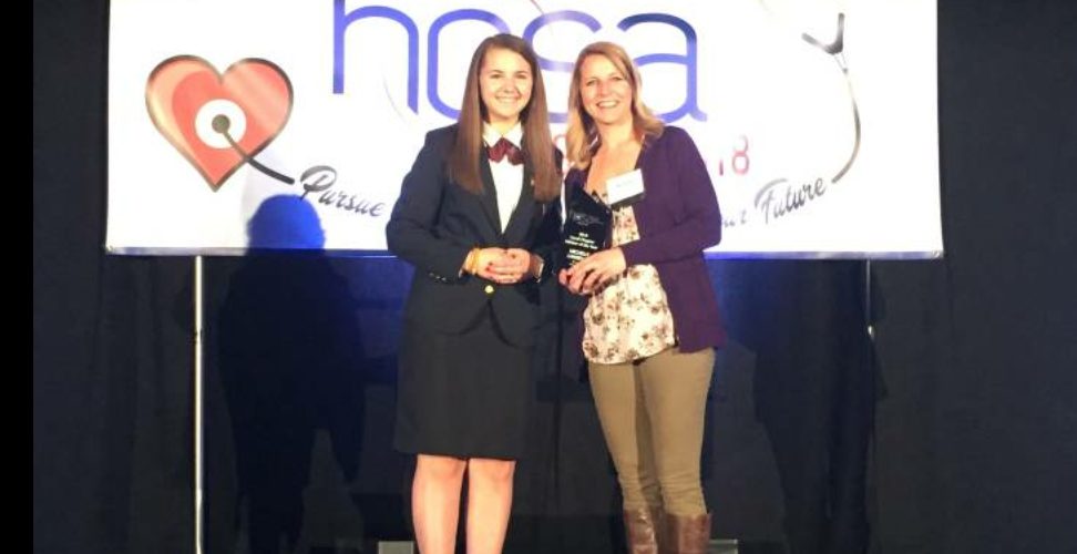 Lawrence receive award on stage at HOSA conference
