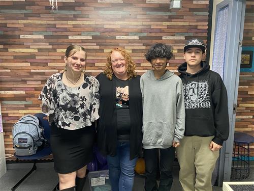 Mrs. Turner stands with 3 teenage students in her class