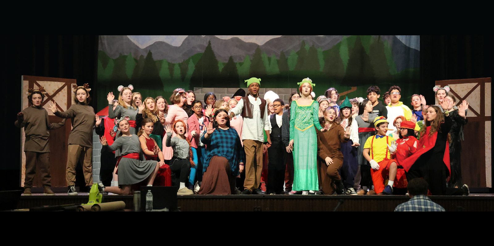 A group of students on stage for a performance of Shrek the Musical, Jr. 