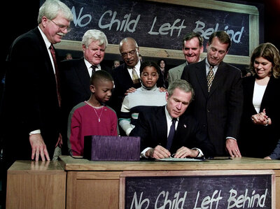 President George W. Bush, seated, signs No Child Left Behind into law at Hamilton High School in Hamilton, Ohio.