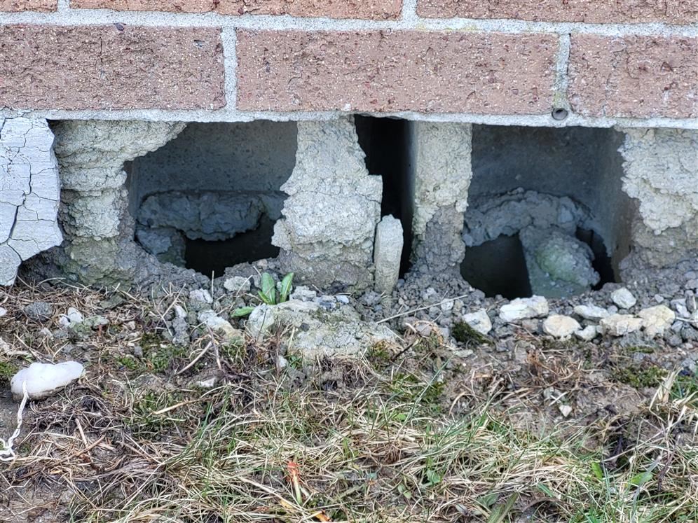 picture shows holes in concrete block of foundation wall
