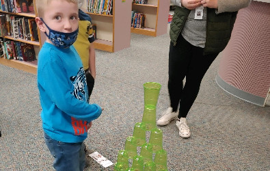 Estudiantes de jardín de infantes trabajando en equipos apilando vasos para construir torres