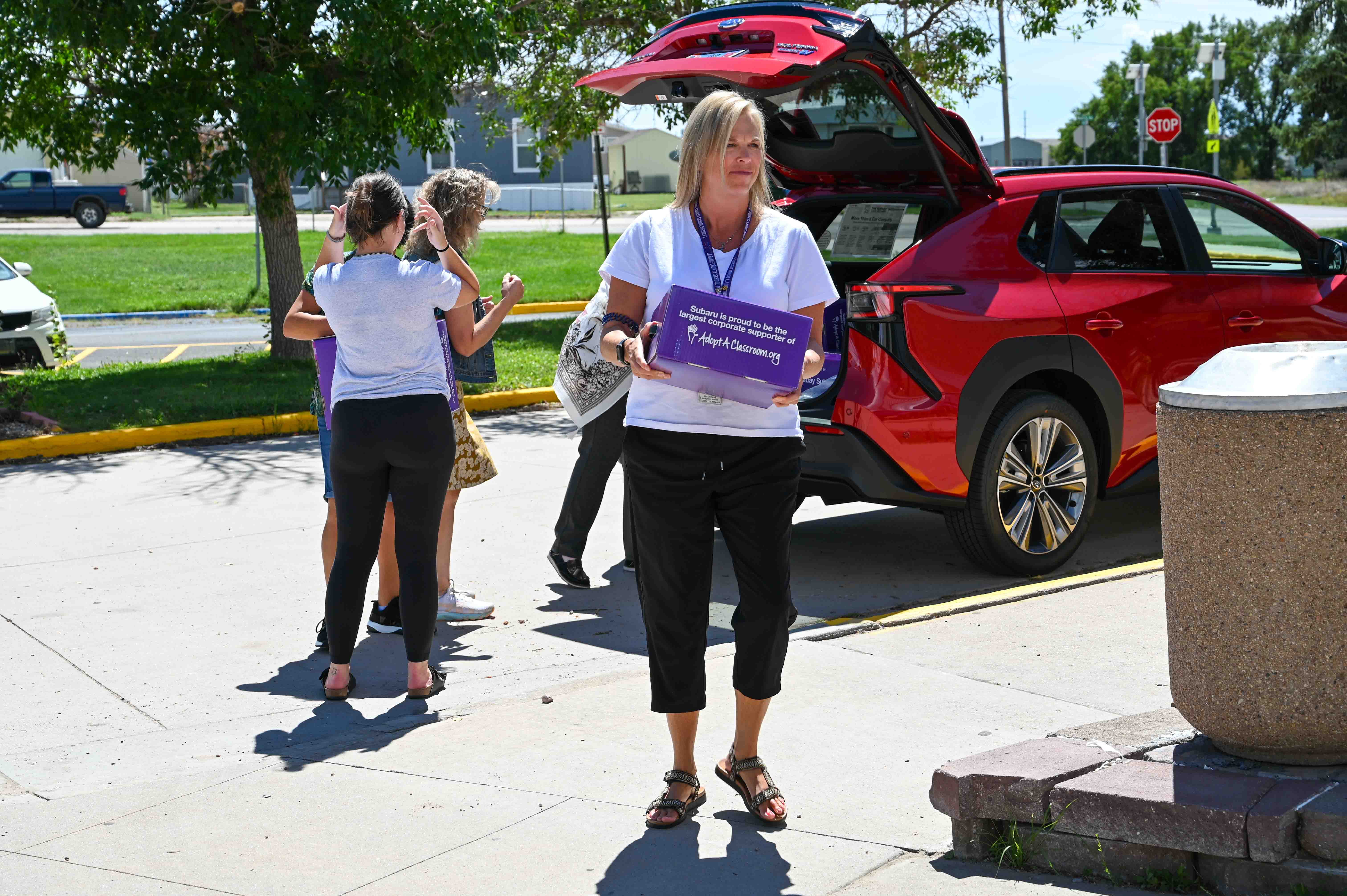 teachers carrying boxes of school supplies