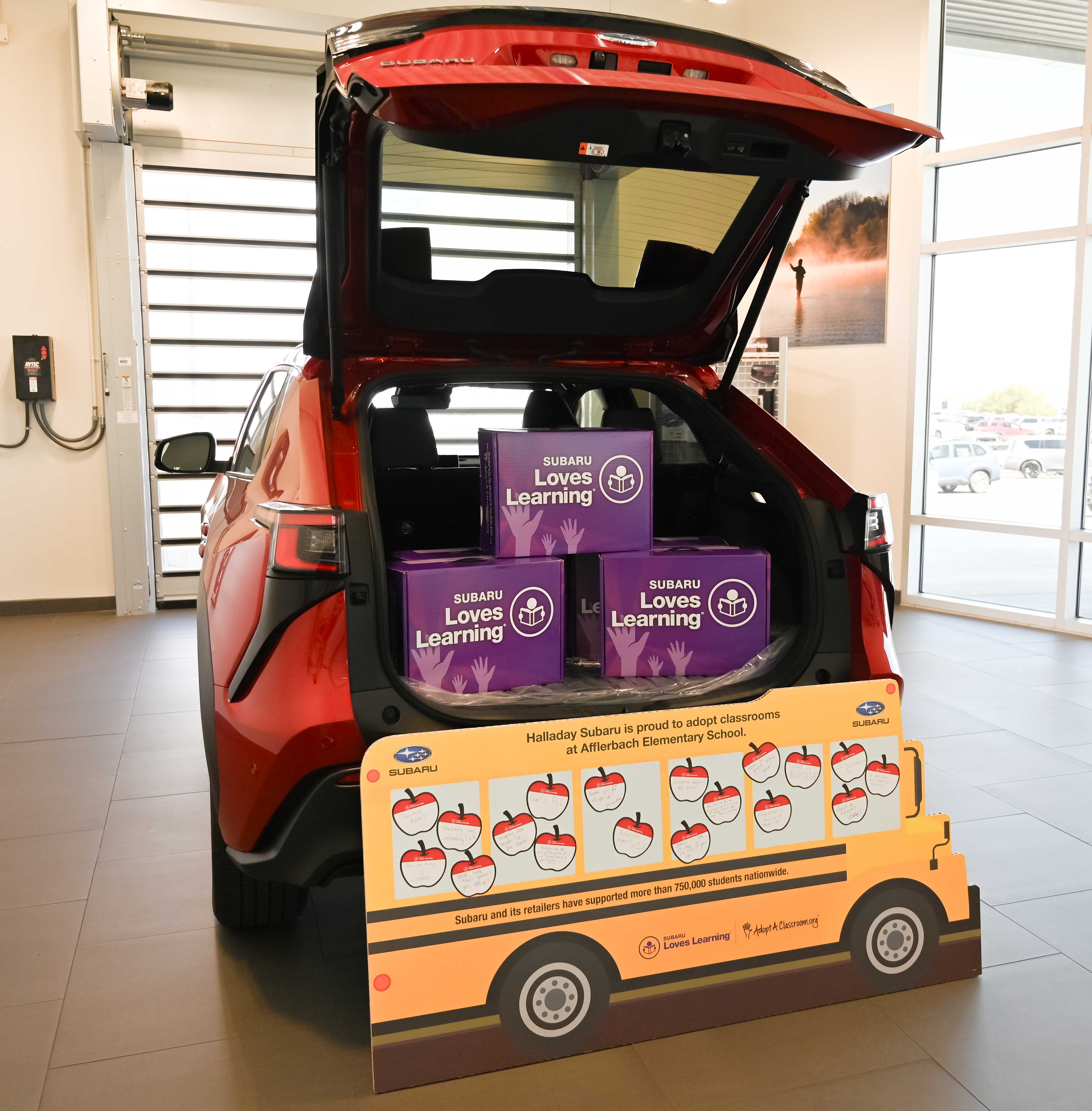 Back of Subaru fill of boxes of donated school supplies