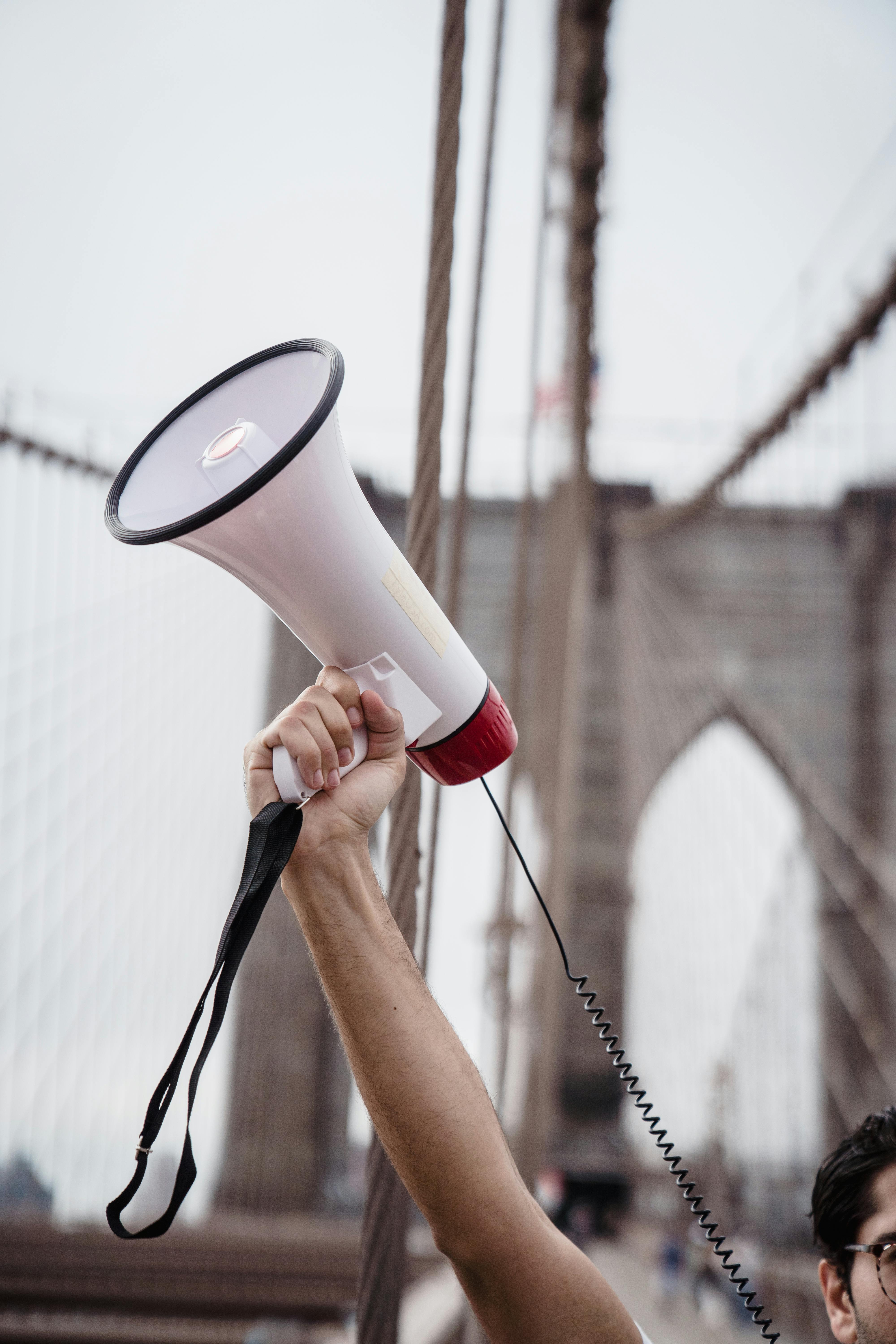 Free Person Holding White and Red Megaphone Stock Photo