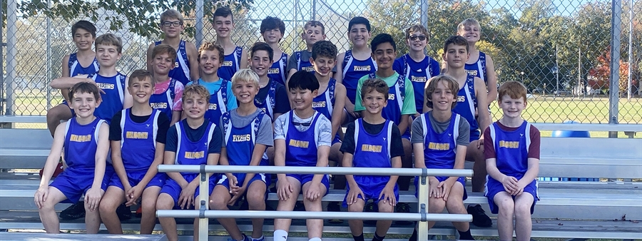 Three rows of Belhaven Boys Cross Country team seated on metal bleachers