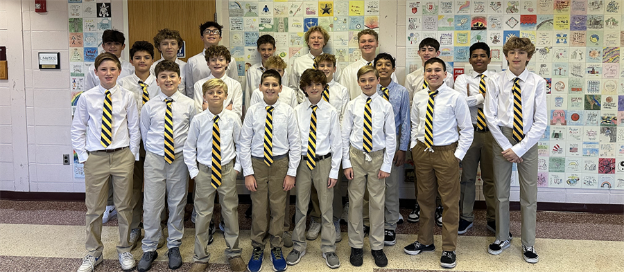 Belhaven boys basketball team dressed in shirts and ties standing in a group.