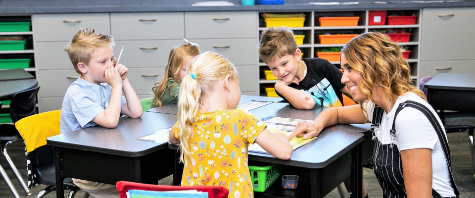 kindergarten classroom with teacher and students around a table