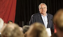 Middle-aged man wearing a grey suit and white dress shirt