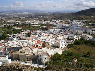View of Níjar with a church in the middle and some green hills in the background