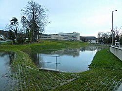 The same pond, full of the water it is detaining, during a flood. Once the peak of the flood has passed, it will slowly drain again.