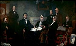 Painting of men sitting at tables or else standing, listening to one of them reading a document