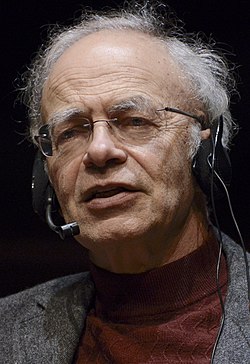 Photo of a man with gray hair speaking through a headset