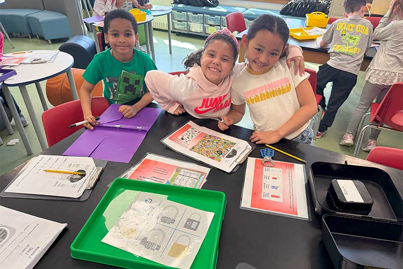 Students smiling at camera while completing module.