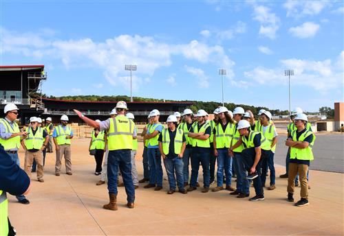 Students fanned out on terrace of stadium under construction. 