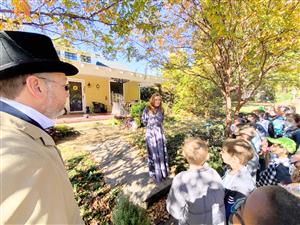 students listening to historical association members talk about the history of a house